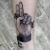 Engraving style black ink arm tattoo of human hand holding key