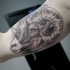 Engraving style black ink biceps tattoo of large goat skull