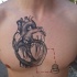 Engraving style black ink chest tattoo of human heart with small bulb and square