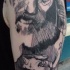 Engraving style black ink shoulder tattoo of old man face with rat