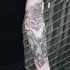 Engraving style black ink sleeve tattoo of bat and flower