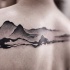 Gravur Stil schwarzes Tattoo am oberen Rücken mit Bergen