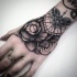 Engraving style black ink wrist tattoo of big rose and ornaments