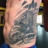 Fantasy style black ink detailed side tattoo of eagle and snake fight