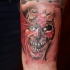 Tatuaggio colorato sul braccio la faccia del demone