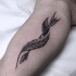 Feather curled around arrow tattoo on biceps