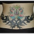 Tatuaje en la espalda baja, 
flor raro con líneas tribales
