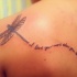 Flying dragonfly and inscription tattoo on shoulder blade