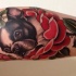 Tatuaggio colorato sul braccio bulldog con i fiori rossi intorno