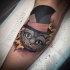 Tatuaje en el brazo,
gato de Cheshire soniente en sombrero de copa