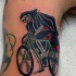 Tatuaje en el brazo,
parca divertida en bicicleta