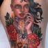 Funny looking colored thigh tattoo of interesting woman portrait, human skull and flowers