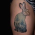 Funny looking colored thigh tattoo of rabbit stylized with forest