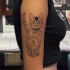 Tatuagem de ombro de tinta preta de estilo geométrico de gato com olhos verdes