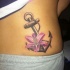 Tatuaje de ancla clásica con flor rosada