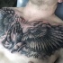 Tatuaje muy espectacular tratando el tema religioso las manos rezando y las alas en el pecho
