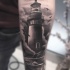 Tatuaje en el antebrazo, faro muy realista con bote pequeño y gaviotas
