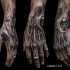 Gorgeous looking black ink detailed wrist and hand tattoo of alien like skeleton