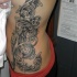 Tatuaje en el costado, patrones de flores, color gris