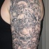 inchiostro grigio sacco di teschi tatuaggio a mezza manica