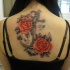 Tatuaje en la espalda, ancla gris grande, y dos rosas