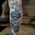 Gray washed style creepy leg tattoo of hand with torch