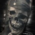 gray washed style detailed arm tattoo of pirate skull with bandage