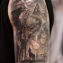 Gray washed style detailed shoulder tattoo of wolf in forest