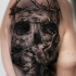 Gray washed style detailed shoulder tattoo of human skull with vine