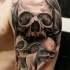 Gray washed style human skulls tattoo on shoulder