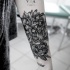 grande disegno nero e bianco floreale tatuaggio con lettere su braccio