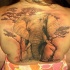 Tatuaje  de elefante entre árboles en la espalda