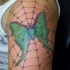Tatuaje en el brazo, polilla verde en la telaraña