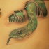 Grüne Schlange kriecht aus Haut Tattoo