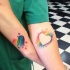Tatuajes en los antebrazos, corazones multicolores para amigos