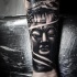 Hinduism style colored forearm tattoo of Buddha statue and old house