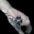Homemade style black ink memorial hand tattoo fo animal paw print and lettering