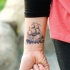 Homemade style black ink wrist tattoo of cool sailing ship