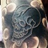 Tatuaje  de cráneo negro con contornos blancos