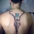 Horned deer skull dotted work back tattoo with colored geometrical style triangles by Adrian Bascur