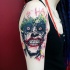 Tatuaje en el brazo, cara de Joker loco sonriente
