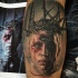 Horror style creepy looking leg tattoo of mysterious monster face with vine