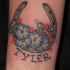 ferro di cavallo con fiore blu e nome tatuaggio