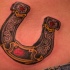 Tatuaje en la espalda baja, 
herradura con ornamento