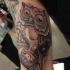 Tatuaje en el brazo, lechuzay cráneo pequeño
