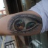Tatuaje en el brazo, ojo surrealista con dos pupilas