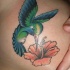 Tatuaggio colorato sul petto il colibrì & il fiore