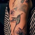Tatuaggio colorato sul braccio il colibrì & i fiori