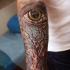 Tatuaje en el brazo, árbol seco  volumétrico y ojo verde