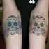 Tatuajes en los antebrazos,
 calaveras de azúcar divertidas multicolores